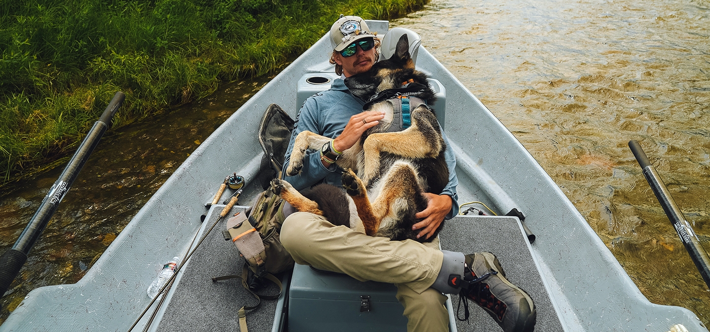 Charles Meier holds his dog in this drift boat