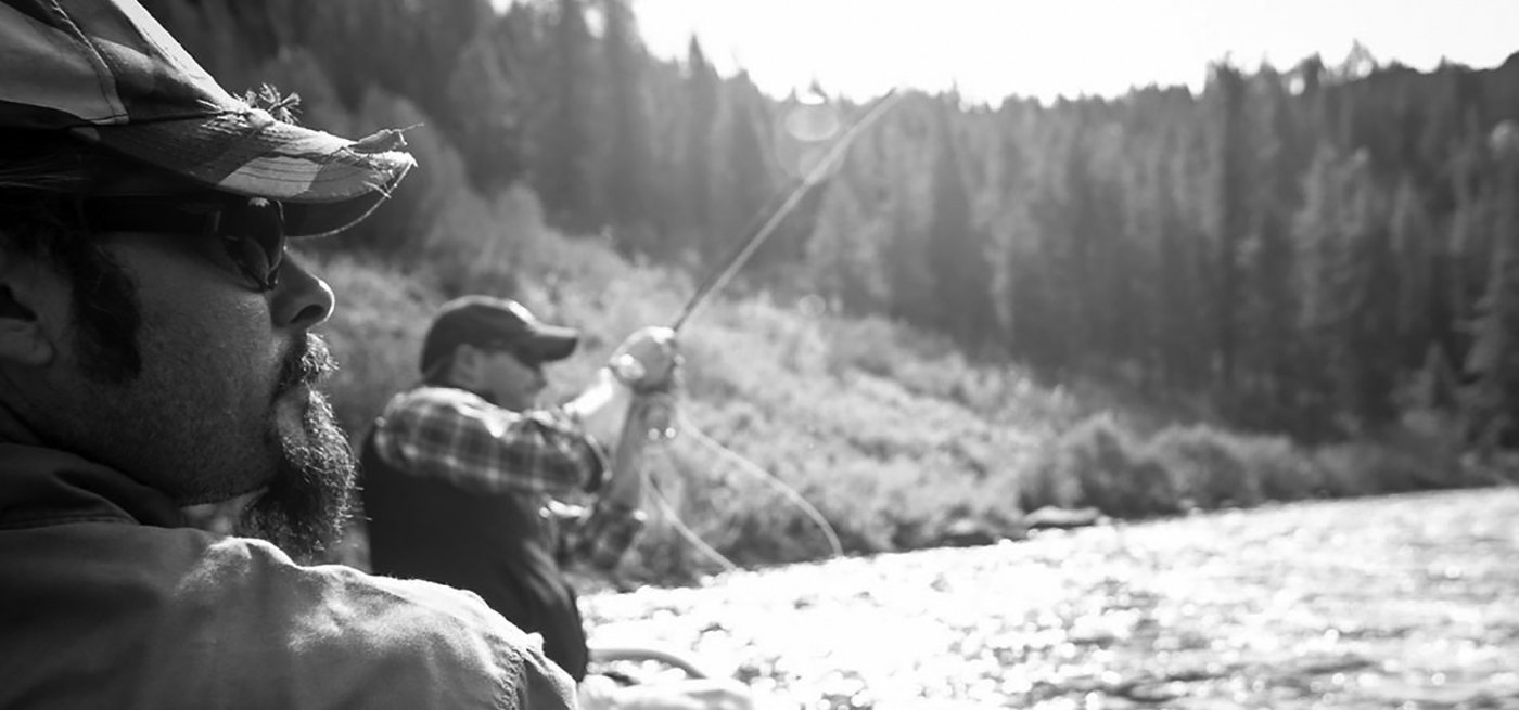 Marty Reed, TroutHunter guide, watches his client reel in a trout.