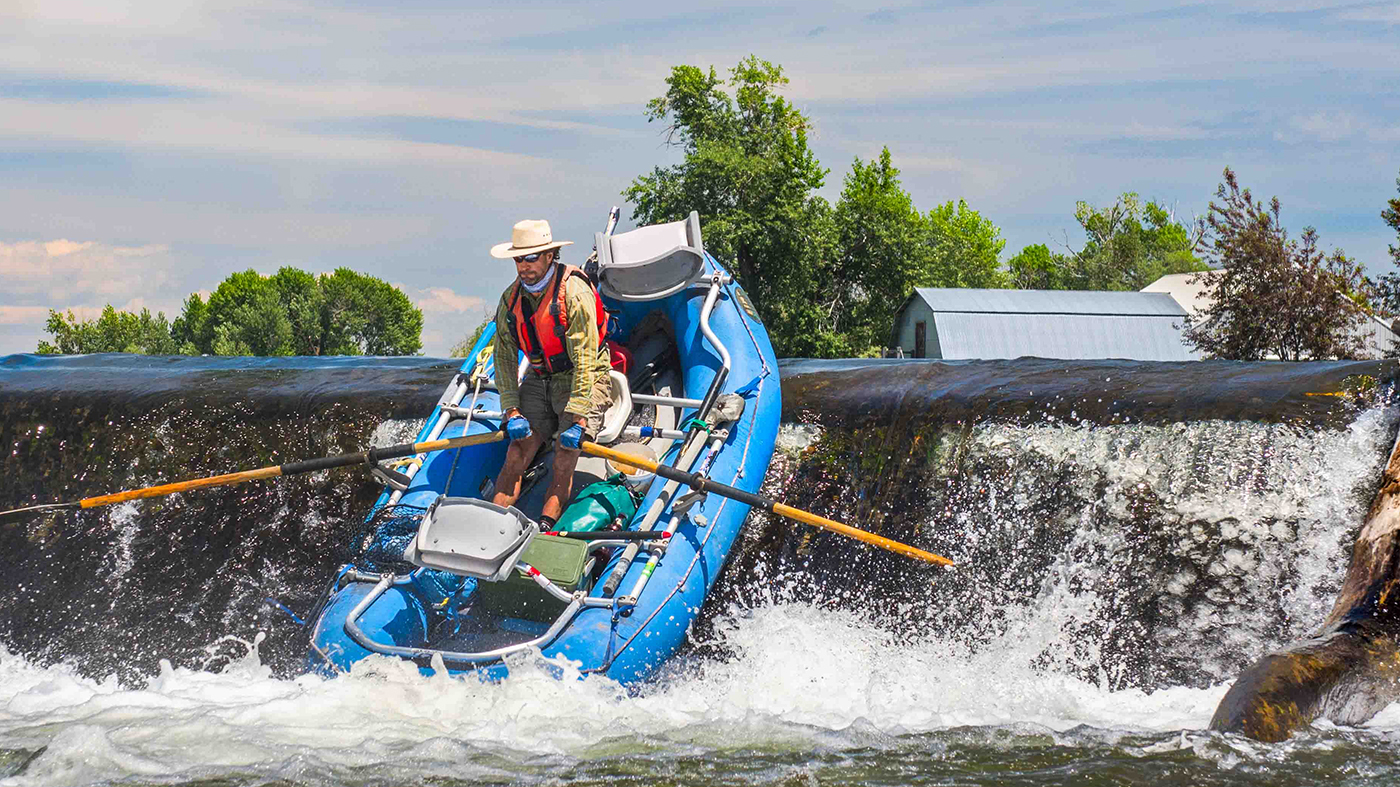 Fly fishing guide shoots over a diversion in a raft