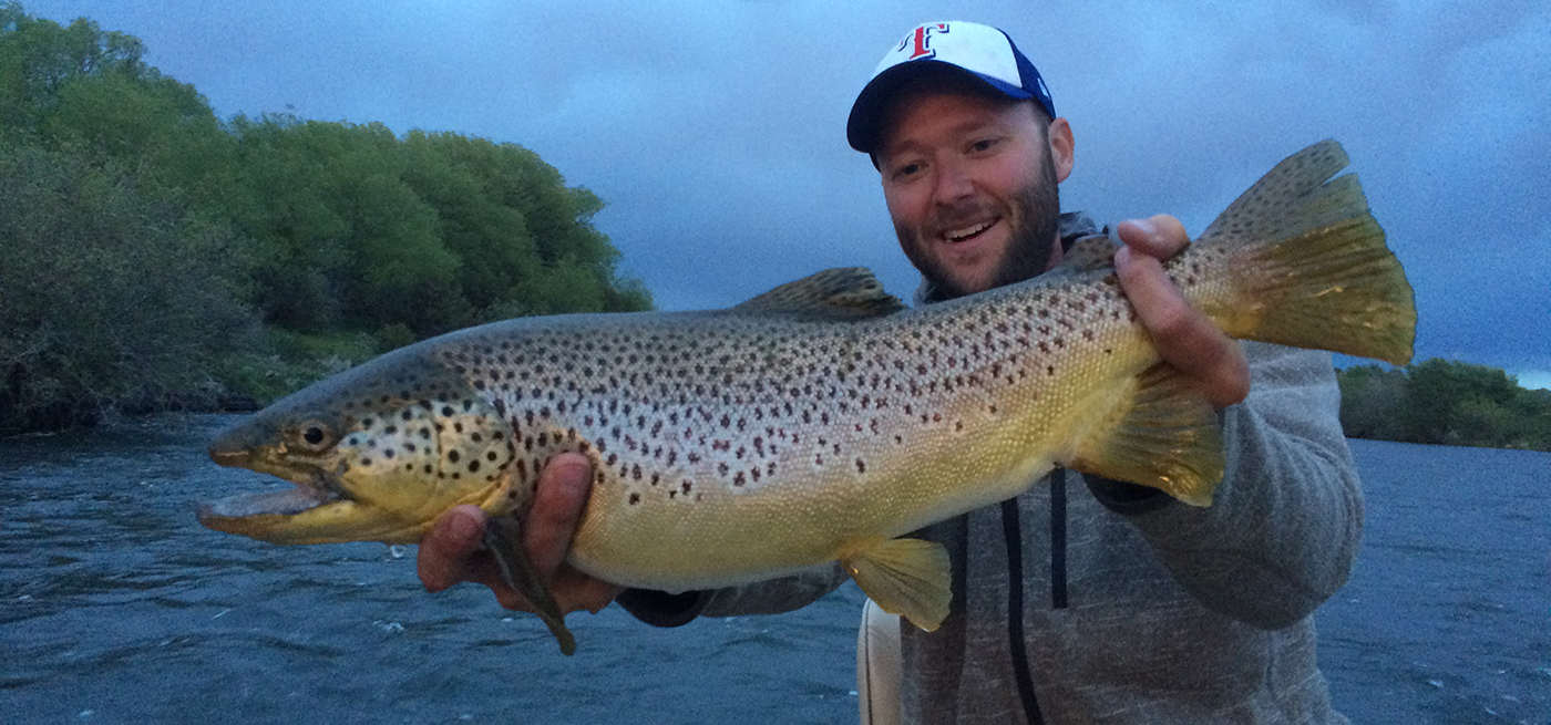 Ryan Loftice, TroutHunter guide, holds up a large brown trout