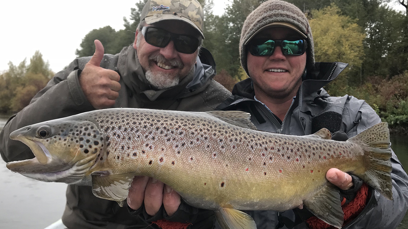 Zach Wheeler and client hold up a large brown trout