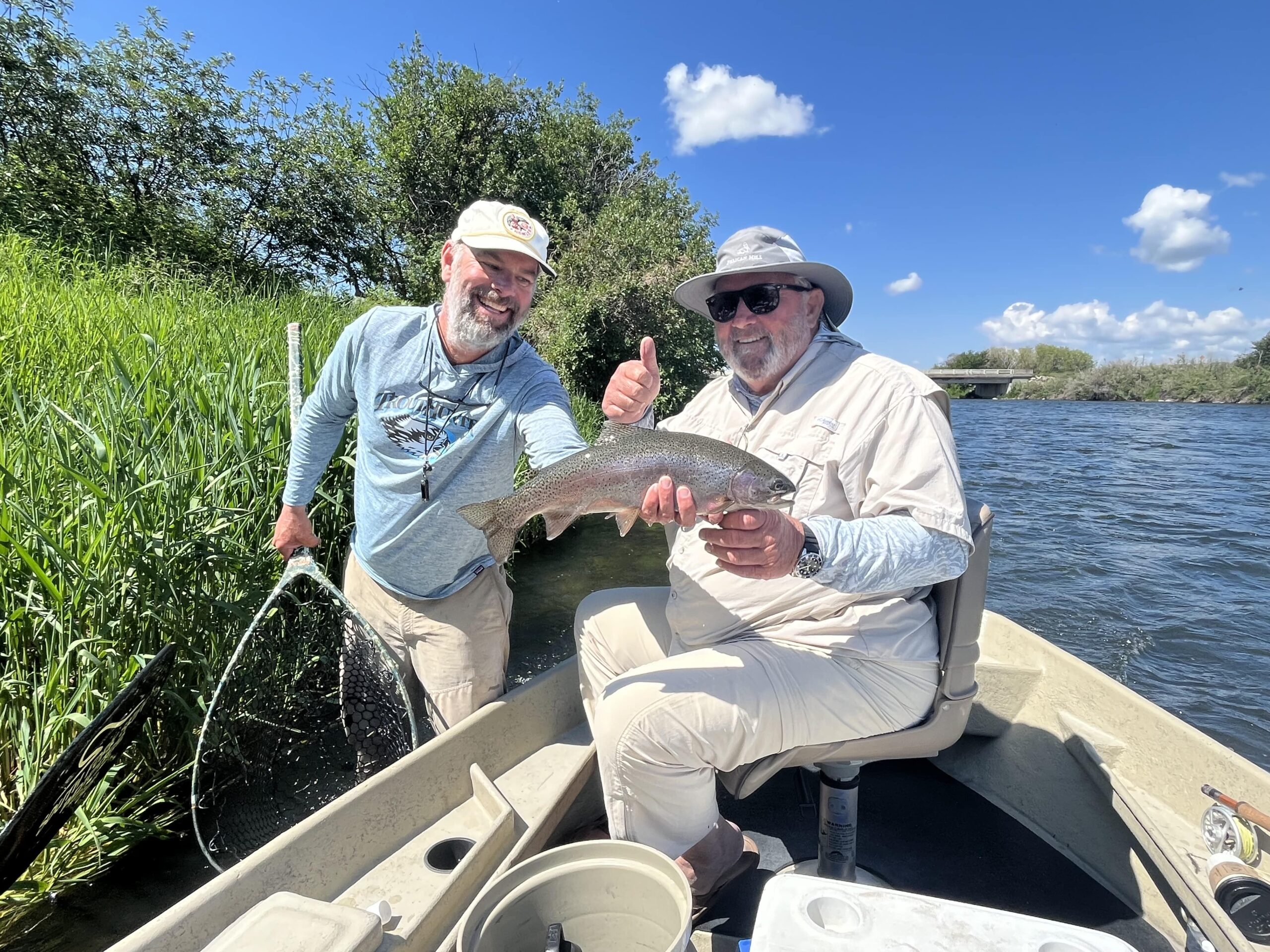 Ben Smith, TroutHunter guide, holds up a large rainbow.